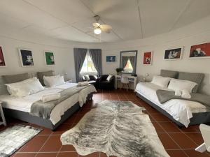 a bedroom with two beds and a living room at Footprints in Kleinmond in Kleinmond