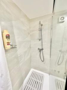 a white bathroom with a shower and a white bench at Loft Marbella Center in Marbella +6 photos
