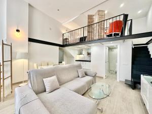 a living room with a couch and a staircase at Loft Marbella Center in Marbella