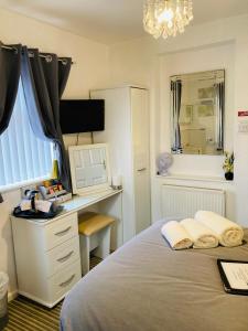 a bedroom with a bed with a desk and a computer at Fairfax in Skegness