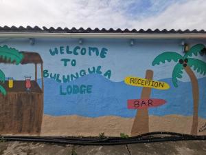 a mural on the side of a building with palm trees at Bulungula Xhosa Community Lodge in Bulungula