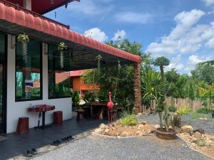 a building with a patio with a flamingo in a garden at บ้านต้นยางคาเฟ่ โฮมสเตย์ ลอร์ด 