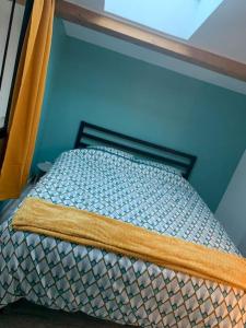 Ce lit se trouve dans un dortoir doté d'un mur bleu. dans l'établissement Le cocon sauternais avec balneo, à Preignac