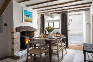 a dining room with a table and a fireplace at Whitsun Cottage in Stow on the Wold