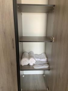un armario con dos toallas plegadas en un estante en Caprios motel en Al Qasţal