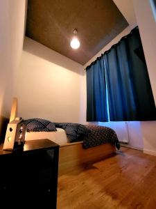 1 dormitorio con 1 cama con cortina azul en Tatarska Sen Apartamenty, en Przemyśl