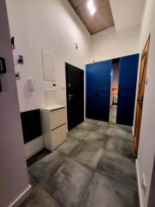 Una habitación vacía con armarios azules y un pasillo. en Tatarska Sen Apartamenty, en Przemyśl 1 foto más
