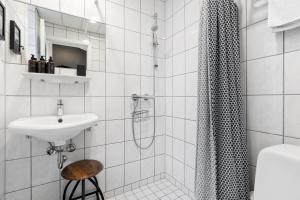 a white bathroom with a sink and a shower at Ibsens Hotel in Copenhagen +29 photos