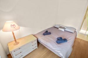 een klein bed in een kamer met een lamp en een dressoir bij Studio chaleureux et paisible in Lens
