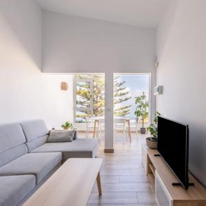 Una sala de estar con un sofá y un televisor. en Coastal Vista: retreat in nature, en Bajamar