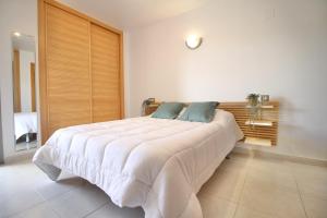 1 dormitorio con 1 cama blanca grande en una habitación en Mediterranean Way - Maldivas, en La Pineda