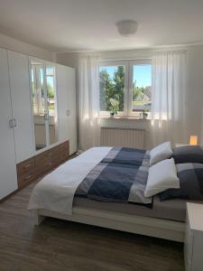 a bedroom with a large bed and two windows at Moderne helle Ferienwohnung in Remagen