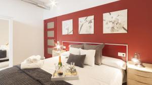 バルセロナにあるApartsNouBcn Industria-Graciaの赤い壁のベッドルーム1室(大型ベッド1台付)