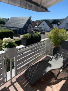 a white fence with potted plants on a patio at Moderne helle Ferienwohnung in Remagen