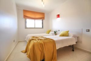 a bedroom with two beds and a window at Mediterranean Way - Maldivas in La Pineda