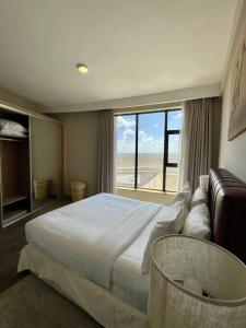 a bedroom with a large bed and a large window at A Scenic Escape within Nairobi in Nairobi