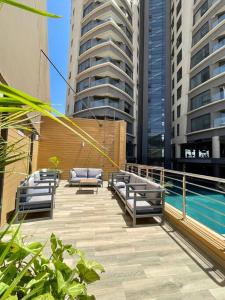 a row of benches next to a pool with buildings at A Scenic Escape within Nairobi in Nairobi