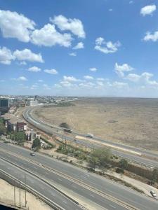 a highway in the middle of a desert with cars at A Scenic Escape within Nairobi in Nairobi