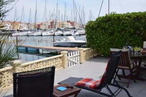 a patio with chairs and tables and boats in a marina at MARINA in Cap d'Agde