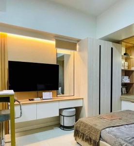 une chambre d'hôtel avec une télévision et un lit dans l'établissement Stunning Bayview Studio in Cebu, à Guizo