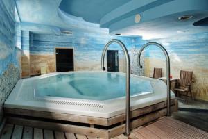 a jacuzzi tub in a room with blue ceilings at Lila Medical SPA in Ciechocinek