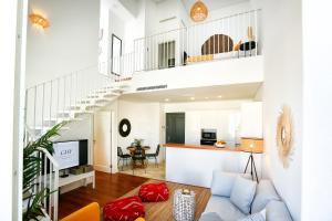 a living room with a blue couch and a staircase at Querido Algarve Apartment in Faro
