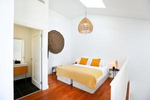 a white bedroom with a bed with orange pillows at Querido Algarve Apartment in Faro +27 photos