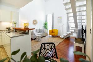 a kitchen and a living room with a couch at Querido Algarve Apartment in Faro