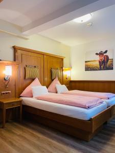 a bedroom with two beds and a cow picture on the wall at Altstadt Hotel Glockenhof in Eltville
