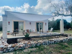 a white house with a porch and a patio at Ca’ dell’Agave-Le more-Villa immersa negli ulivi in Surano