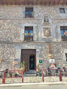 un edificio de piedra con bancos frente a una puerta en Las Huellas de Cameros, en Soto en Cameros