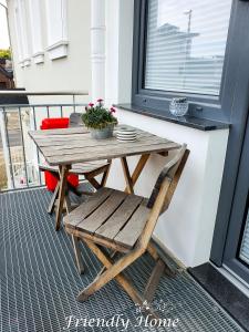 a wooden table and a chair on a porch at Friendly Home - Einzelappartement "Trust" Köln Bonn Phantasialand in Brenig