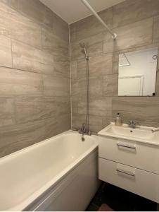 Spacious,1 bed, balcony, Southwark Central London في لندن: حمام مع حوض ومغسلة وحوض استحمام