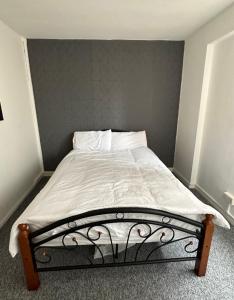 un letto in una camera da letto con parete grigia di Spacious,1 bed, balcony, Southwark Central London a Londra