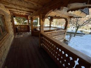 einen Außenblick auf eine Holzhütte mit einer Veranda in der Unterkunft Casa Botiza - Cătun in Sinaia