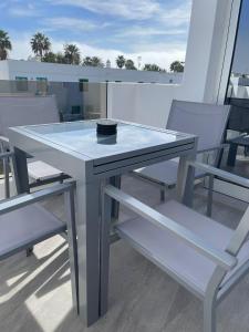 a glass table and chairs on a balcony at Rociaga 35 Apartment 8, 100 meters to sea front in Puerto del Carmen
