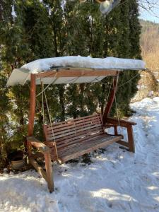 a swing in the snow with snow on it at Casa Botiza - Cătun in Sinaia