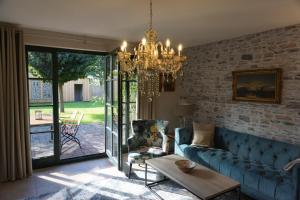 a living room with a blue couch and a chandelier at Landhaus Storchennest - komfortable Appartements für 2-5 Personen in Reestow