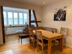a dining room with a wooden table and chairs at Haus Bergblick "Staufen" mit 2 Schlafzimmer in Oberstaufen