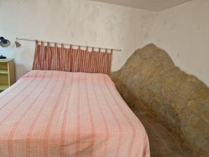 Bett mit einer roten und weißen gestreiften Decke in einem Zimmer in der Unterkunft Tavernetta Giuseppe Verdi in Ugento