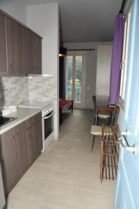 a kitchen with wooden cabinets and a table and chairs at Andros Guesthouses in Andros