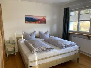 a bedroom with a bed with two pillows on it at Haus Bergblick "Staufen" mit 2 Schlafzimmer in Oberstaufen