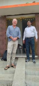 dois homens de pé nos degraus de uma casa em Budha ashram guest house em Bodh Gaya