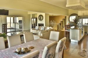 a kitchen and living room with a table and chairs at Bayview 8 Sleeper Langebaan in Langebaan