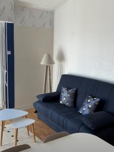 a blue couch in a living room with a table at Studio vue sur mer in La Chaume