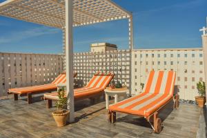 three orange chairs sitting on a rooftop patio at Stella 4 - studio deluxe, rooftop en médina in Essaouira