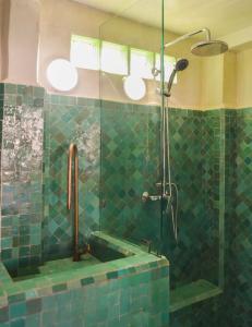 a green tiled bathroom with a shower with a sink at Stella 4 - studio deluxe, rooftop en médina in Essaouira