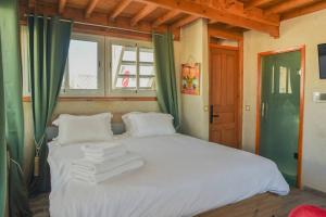 a bedroom with a large white bed with green curtains at Stella 4 - studio deluxe, rooftop en médina in Essaouira