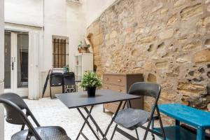 a table and chairs in front of a stone wall at Sweety home in center of Paris in Paris