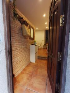 un pasillo con una pared de ladrillo y una puerta abierta en La Casita del Camino, en Redondela